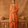 Model wearing peach gold embroidered salwar suit with matching dupatta and traditional jewelry