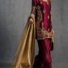 Model display: Elegant maroon handcrafted ethnic dress styled with golden dupatta for festive occasions.