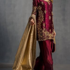 Model display: Elegant maroon handcrafted ethnic dress styled with golden dupatta for festive occasions.