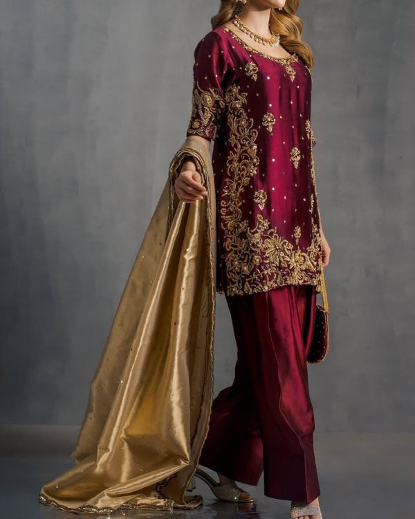 Model display: Elegant maroon handcrafted ethnic dress styled with golden dupatta for festive occasions.