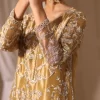 Detailed silver thread embroidery on golden silk fabric, showing sleeve and cuff design of a handcrafted ethnic dress.