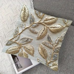 Luxury golden embroidered cushion cover with leaf motifs and silver bead accents, ideal for festive home decoration.