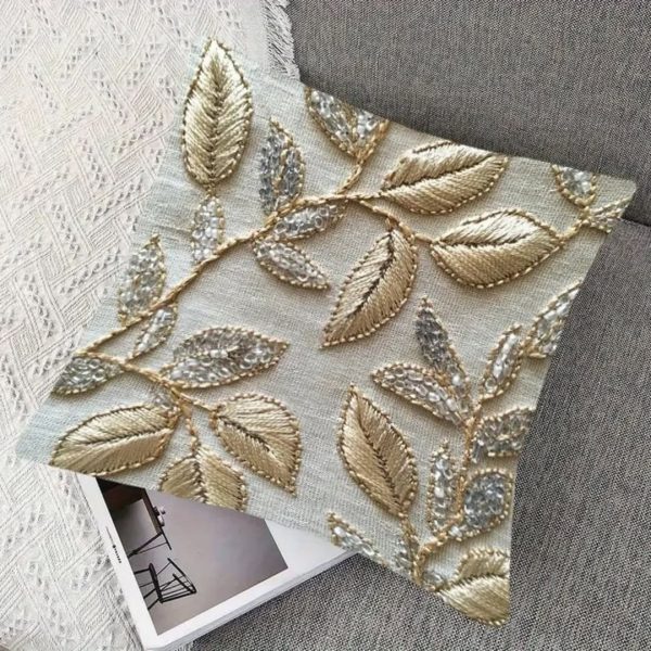 Luxury golden embroidered cushion cover with leaf motifs and silver bead accents, ideal for festive home decoration.