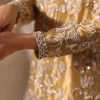 Embroidered cuff and floral motif detail on luxury golden ethnic wear for women.