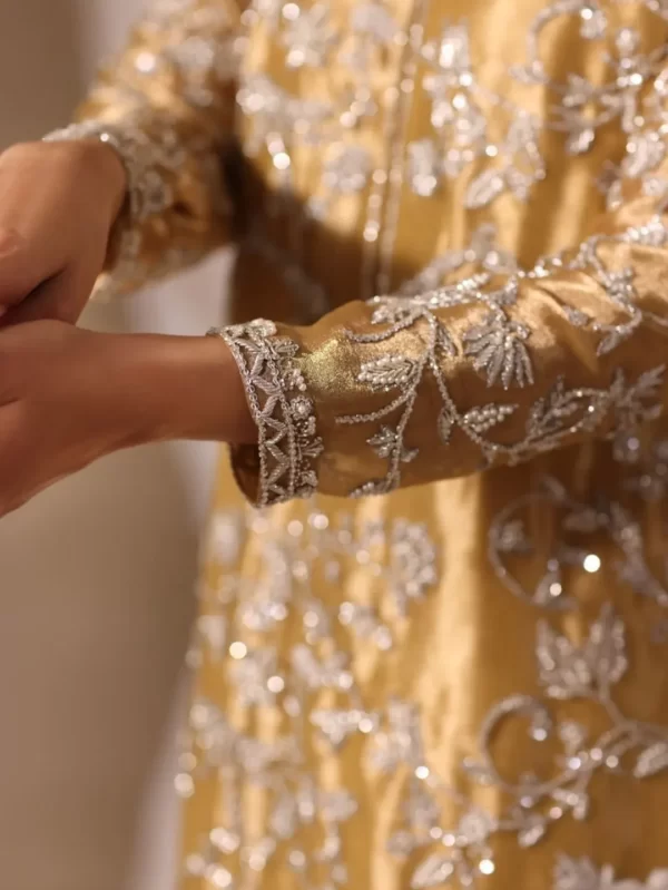 Embroidered cuff and floral motif detail on luxury golden ethnic wear for women.