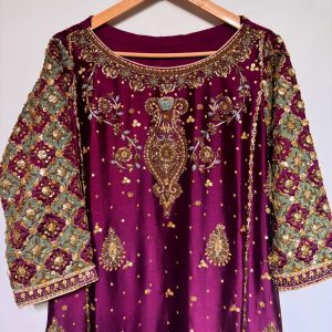 Ornate hand-embroidered lattice sleeve detail on maroon ethnic dress.