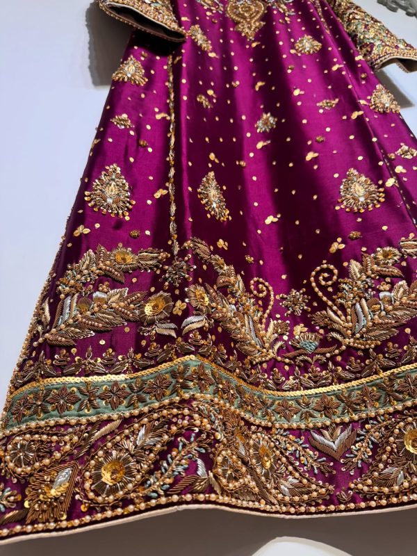 Ornate hand-embroidered lattice sleeve detail on maroon ethnic dress.