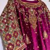 Ornate hand-embroidered lattice sleeve detail on maroon ethnic dress.
