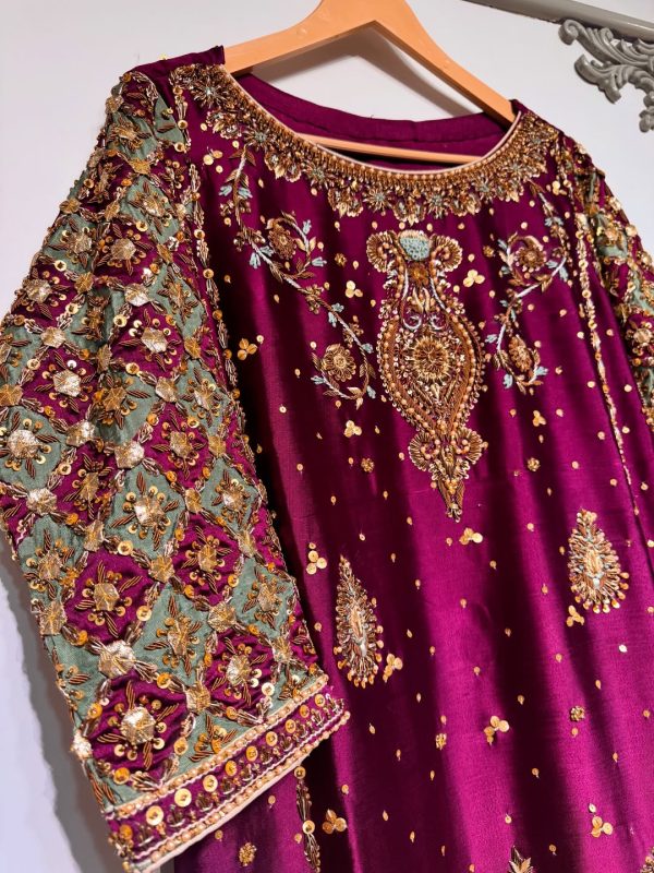 Ornate hand-embroidered lattice sleeve detail on maroon ethnic dress.