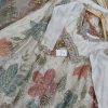 Sequinned pastel pink, blue, and green hand-embroidered flowers on ivory lehenga.