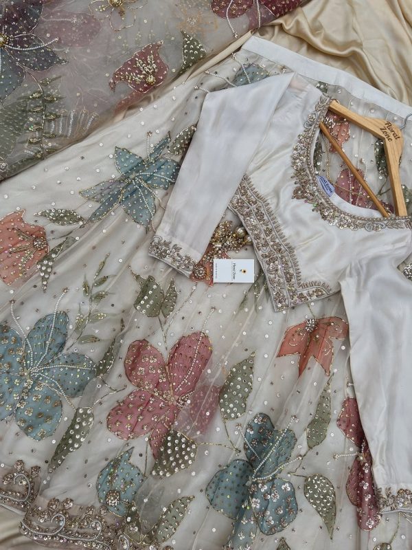 Sequinned pastel pink, blue, and green hand-embroidered flowers on ivory lehenga.