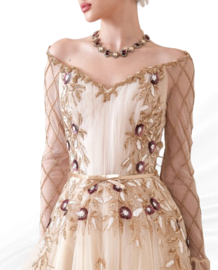 Close-up of champagne evening gown with intricate gold embroidery and maroon floral accents